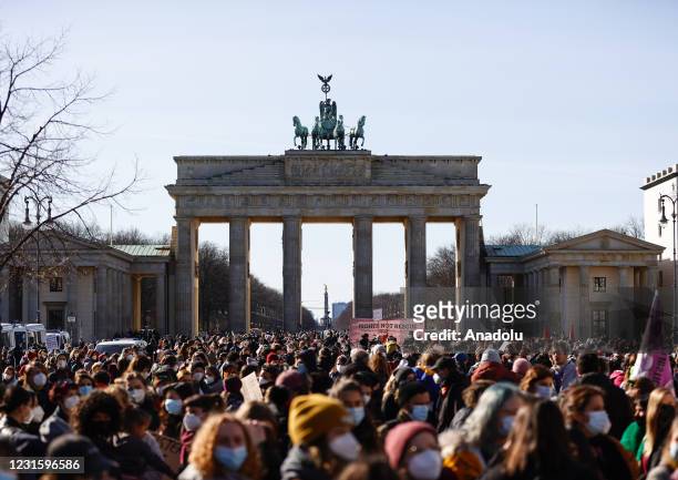 Women march on the Unter den Linden street in company with police during a demonstration to mark the International Women's Day near the Brandenburg...