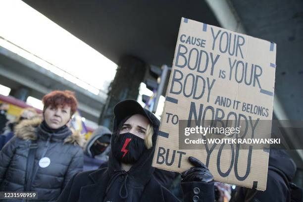 Demonstrators wearing face protection masks with the red lightning bolt, the symbol of the Polish women's strike movement, take part in a protest...