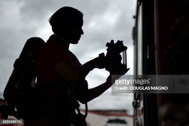 Brazilian firefighter prepares her fire fighting equipment at the second battalion of the Fire Department of Minas Gerais, in Contagem, Brazil, on...