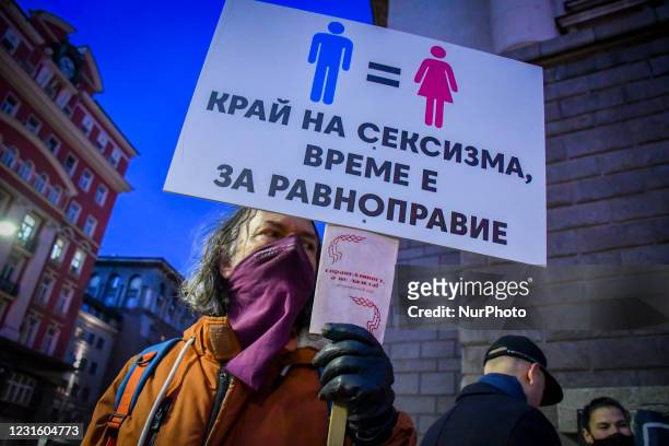 Man holding sign &quot;End sexism. It's time for equity&quot; during a rally on the streets of Sofia for gender equality and womens rights on the...