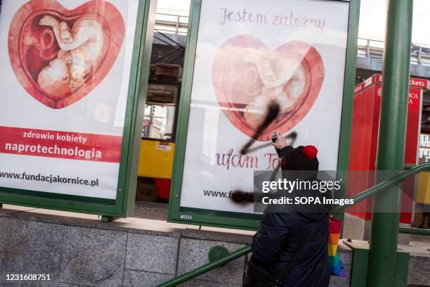 Woman is seen spraying a pro-life campaign poster during the protest. People took the streets in Warsaw on 8th of March in a protest under the slogan...