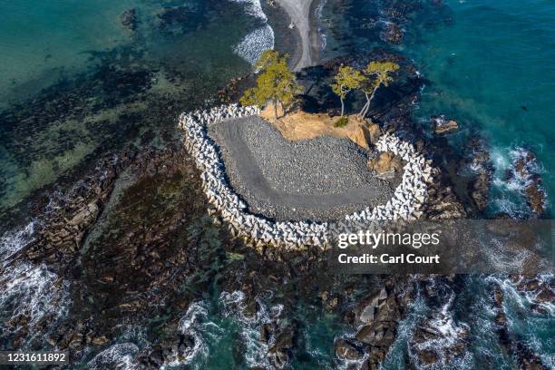 In this view from a drone, concrete tetrapods partially surround a tidal island in Kesennuma where 1023 people were killed in the 2011 tsunami and...