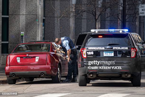 Minneapolis Police officer checks a suspicious car without a plate parked near the Hennepin County Government Center as the jury selection begins at...