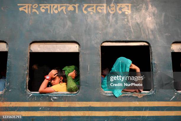 People leave for village by train at Kamalapur railway station in Dhaka on March 10, 2021.