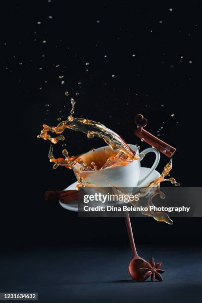 coffee cup with a splash balancing on a wooden spoon - coffee slow motion stock pictures, royalty-free photos & images