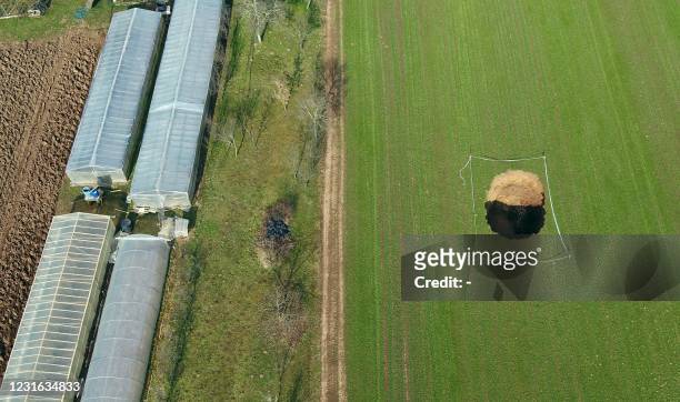 An aerial picture taken on March 10, 2021 shows a sinkhole in the village of Mecencani. The region about 40 kilometers southwest of the capital,...