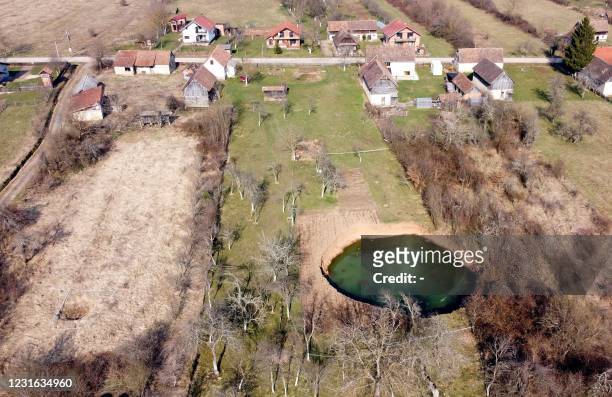 An aerial picture taken on March 10, 2021 shows a sinkhole in the village of Mecencani. - The region about 40 kilometers southwest of the capital,...
