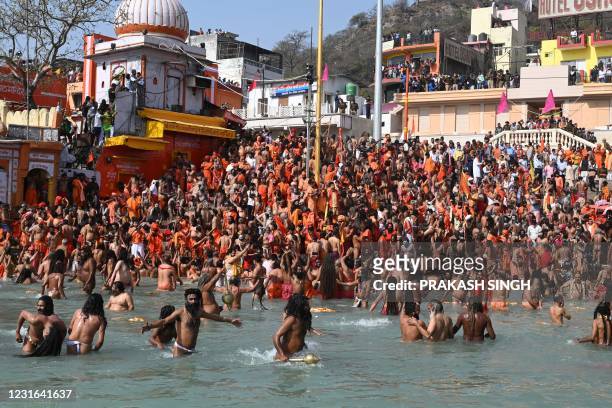 Naga Sadhus take holy dip in the waters of the River Ganges on the Shahi snan on the occasion of Maha Shivratri festival during the ongoing religious...