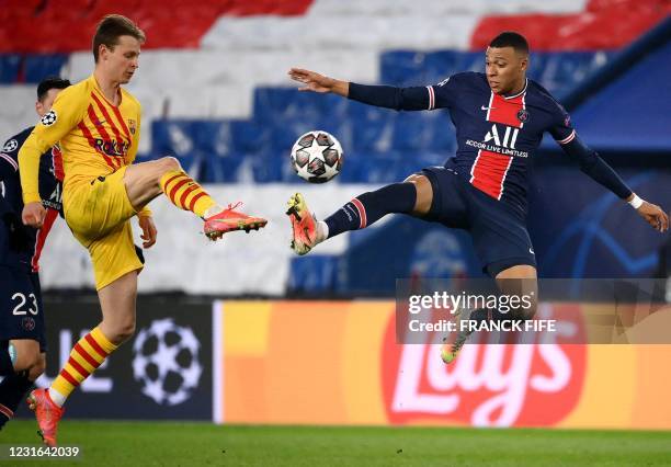 Barcelona's Dutch midfielder Frenkie De Jong fights for the ball with Paris Saint-Germain's French forward Kylian Mbappe during the UEFA Champions...