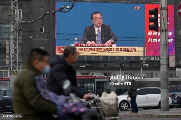 Big screen shows Chinese Premier Li Keqiang speaking during a press conference after the closing session of the National Peoples Congress, in Beijing...