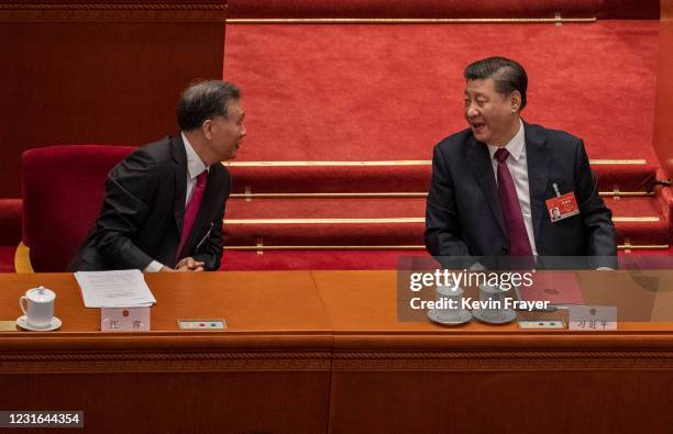 China's President Xi Jinping, right, talks with Politburo member Wang Yang , left, during the closing session of the National People's Congress at...