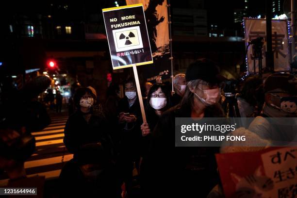 People take part in an anti-nuclear protest outside Tokyo Electric Power Company Holdings headquarters in Tokyo on March 11 on the 10th anniversary...