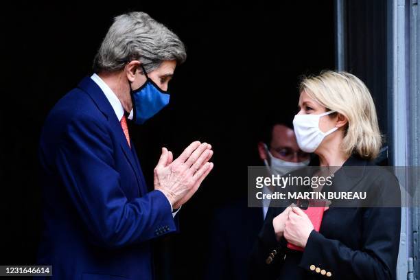 Climate envoy John Kerry and French Ecological Transition Minister Barbara Pompili salute each other following their meeting at the Hotel de...