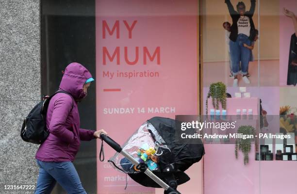 Person pushes a pram passed a mothers day advert in a shop window in Stirling, as lockdown measures for mainland Scotland continue. Picture date:...