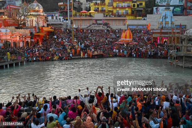Hindu devotees attend evening prayers after taking a holy dip in the waters of the River Ganges on the Shahi Snan on the occasion of the Maha...
