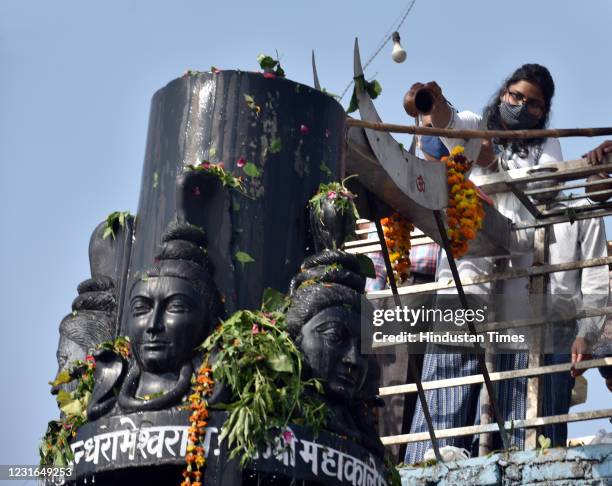 Hindu Devotees offer milk and water over a Shivling inside a temple during the Maha Shivratri festival at Preet Vihar on March 11, 2021 in New Delhi,...