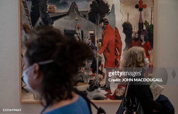 Visitors walk past German painter Neo Rauch's painting "Der Stammbaum" during a press preview of his exhibition "Der Beifang" at the Gutshaus...