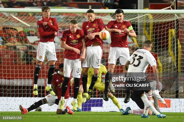 Milan's Bosnian midfielder Rade Krunic fires a free kick into the defensive wall of Manchester United's English defender Brandon Williams, Manchester...