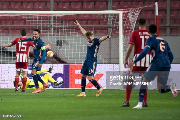 Arsenal's Norwegian forward Martin Odegaard celebrates after scoring his team's first goal during the UEFA Europa League round of 16 first-leg...