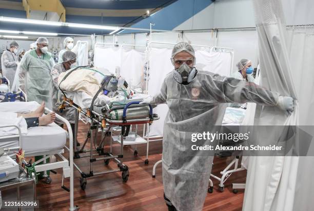 Medical staff members transport a patient on a stretcher at the Pedro DellAntonia Sports Complex field hospital as coronavirus cases soar on March...