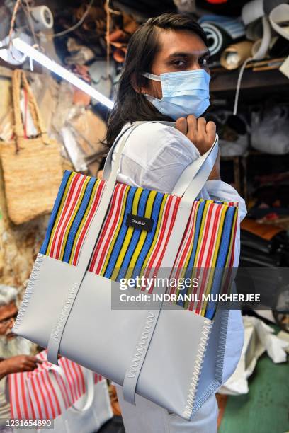 In this photo taken on February 2 founder of 'Chamar Studio', Sudheer Rajbhar poses as he shows his bags made from recycled rubber, at a workshop...