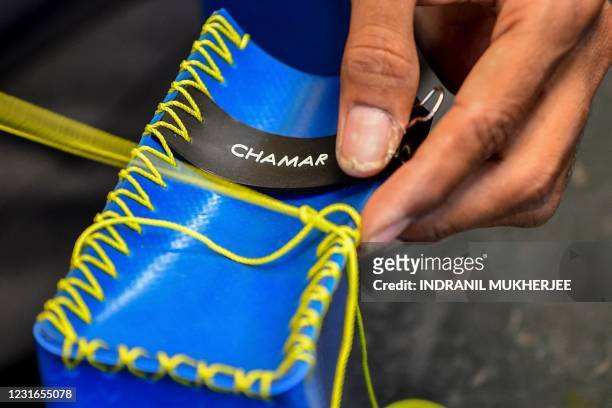 In this photo taken on February 2 artisan Rahul Dattatrey Gorey stitches a new recycled rubber bag for 'Chamar Studio' by designer Sudheer Rajbhar ,...