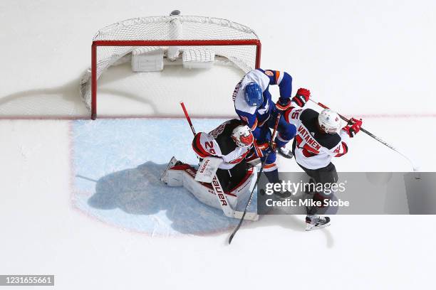 Oliver Wahlstrom of the New York Islanders crashes into Mackenzie Blackwood of the New Jersey Devils on a goal scored by Noah Dobson during the...