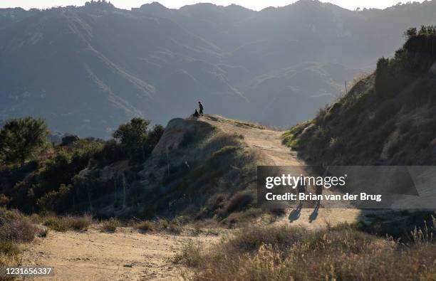 Hikers walk along a wide trail in the Santa Monica Mountains near Eagle Rock along the Backbone Trail in Topanga State Park on Wednesday, Feb. 17,...