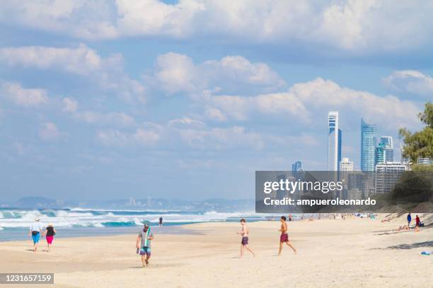 people enjoying the beach at the spit wharf - main beach, gold coast, queensland - main beach gold coast stock pictures, royalty-free photos & images