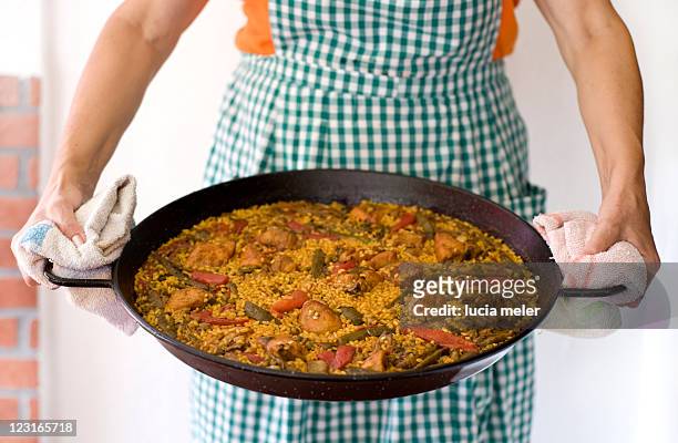 cooker holds freshly cooked paella - paella stock-fotos und bilder