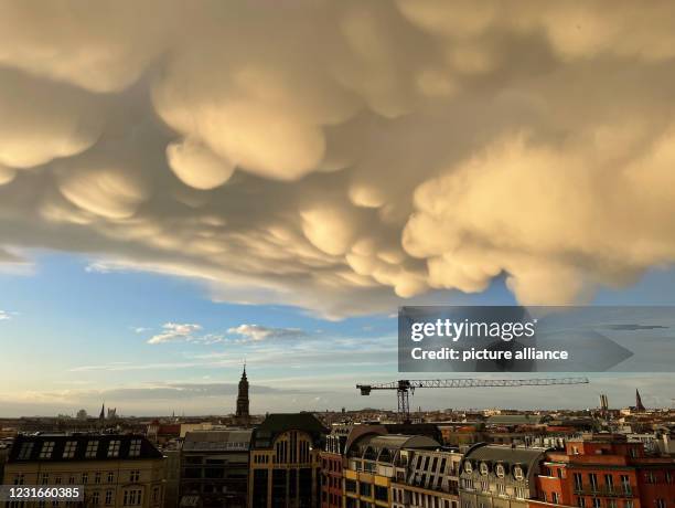 March 2021, Berlin: After a thunderstorm, downward curving, so-called mammatus clouds pass over Hack's Market. This is a rare natural phenomenon....