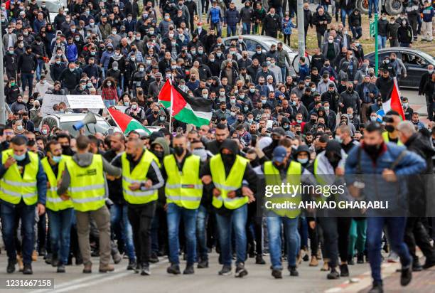 Arab Israelis march together during a demonstration in the mostly Arab city of Umm al-Fahm in northern Israel on March 12, 2021 against organised...