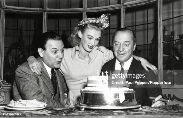 Left to right, Naunton Wayne, Susan Shaw and Basil Radford, English actors, on the set of the film "It's Not Cricket", circa 1949.