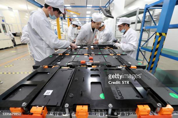 This photo taken on March 12, 2021 shows workers at a factory for Xinwangda Electric Vehicle Battery Co. Ltd, which makes lithium batteries for...