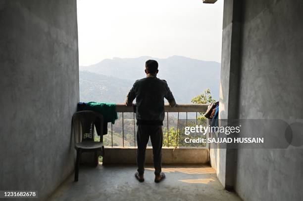 Myanmarese soldier, who fled Myanmar and crossed illegally to India, looks out from the balcony of a temporary shelter at an undisclosed location in...