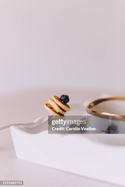 three mini pancakes stacked on a fork setting on a white serving tray - small portion stock pictures, royalty-free photos & images