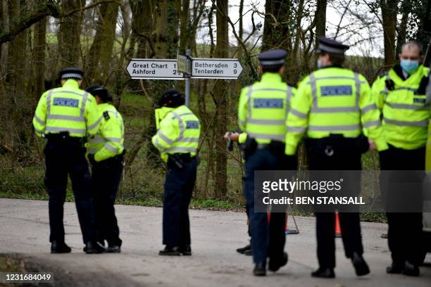 Police officers gather at a roadblock on the road to Great Chart Golf and Leisure near Ashford, southeast England on March 13 following confirmation...
