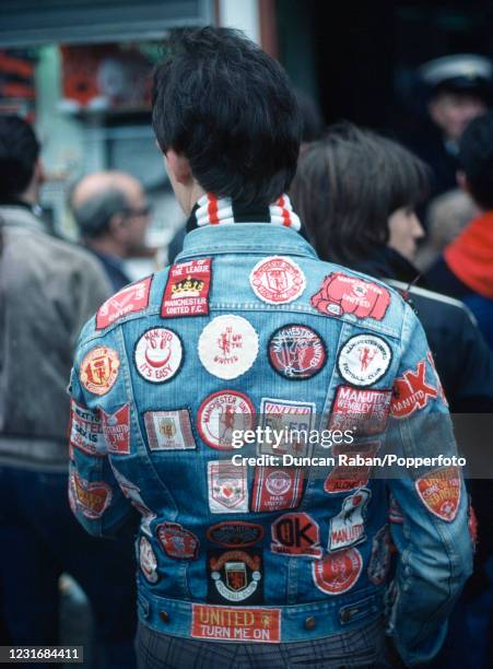 Manchester United fan showing off his badges on the back of his denim jacket before the Canon League Division One match between Manchester United and...