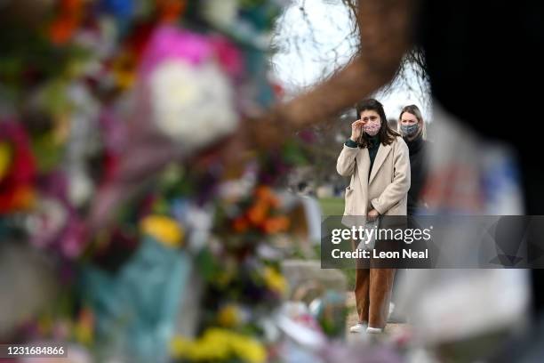 Woman wipes her eye as she stands before tributes for Sarah Everard at the bandstand on Clapham Common on March 13, 2021 in London, United Kingdom....
