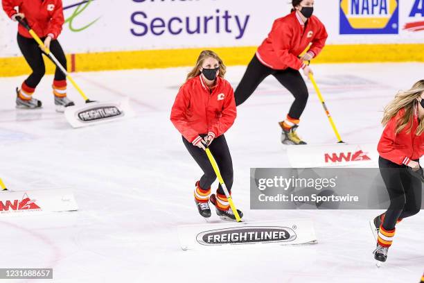 Members of the Calgary Flames ice crew shovel snow between plays during the third period of an NHL game where the Calgary Flames hosted the Montreal...