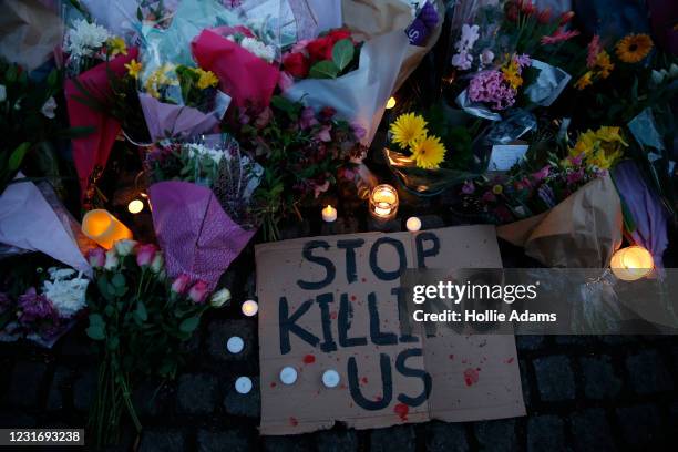 Sign saying "STOP KILLING US" is seen among the flowers and candles on Clapham Common where floral tributes have been placed for Sarah Everard on...