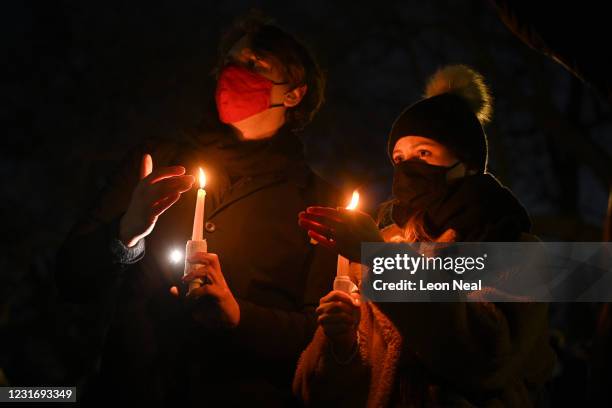 Members of the public hold candles as they gather for a vigil for Sarah Everard at the bandstand on Clapham Common on March 13, 2021 in London,...