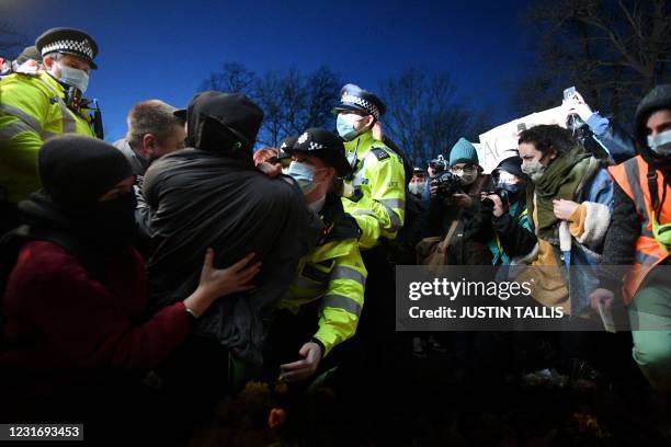 Police officers scuffle with people gathering at a band-stand where a planned vigil in honour of alleged murder victim Sarah Everard was cancelled...