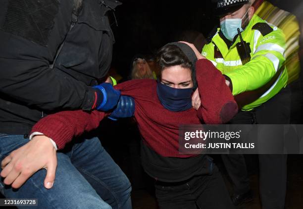 Police officers scuffle with people gathering at a band-stand where a planned vigil in honour of alleged murder victim Sarah Everard was cancelled...