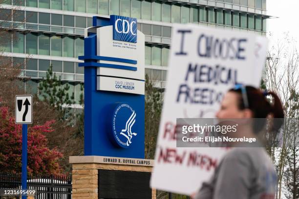 People are seen at a protest against masks, vaccines, and vaccine passports outside the headquarters of the Centers for Disease Control on March 13,...
