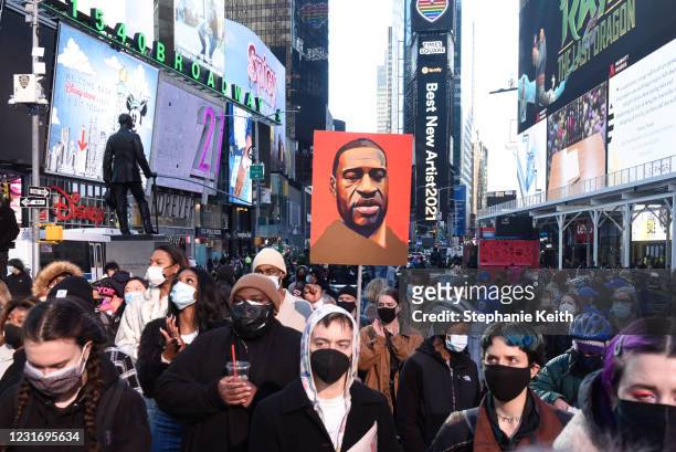 Person holds a placard with George Floyd's face during a protest to mark the one year anniversary of Breonna Taylor's death on March 13, 2021 in New...