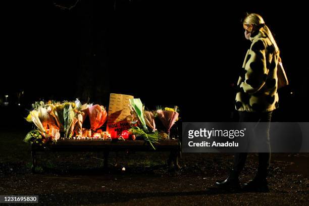 Woman looks at a bench covered in flowers, messages of condolence and candles as mourners for the life of murdered 33-year-old Sarah Everard, whose...