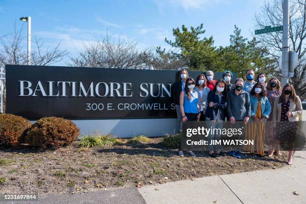 Baltimore Sun reporters gather in front of their sign during an interview in Baltimore, Maryland on March 11, 2021. - After years of staff cuts,...