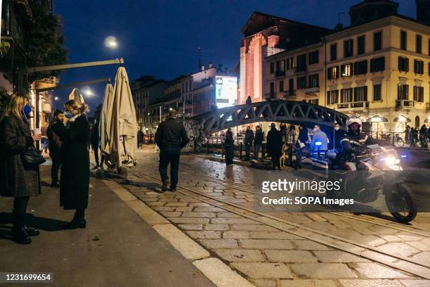 Policeman on a motorbike rides in Navigli area. Starting from March 6, Lombardy region was classified as strengthened Orange Zone, almost reaching...