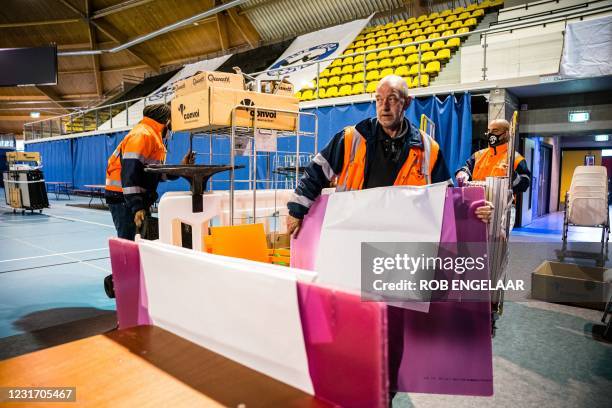 Workers begin to errect voting booths at an indoor sports center that will serve as a center for citizens to vote in the House of Representatives...